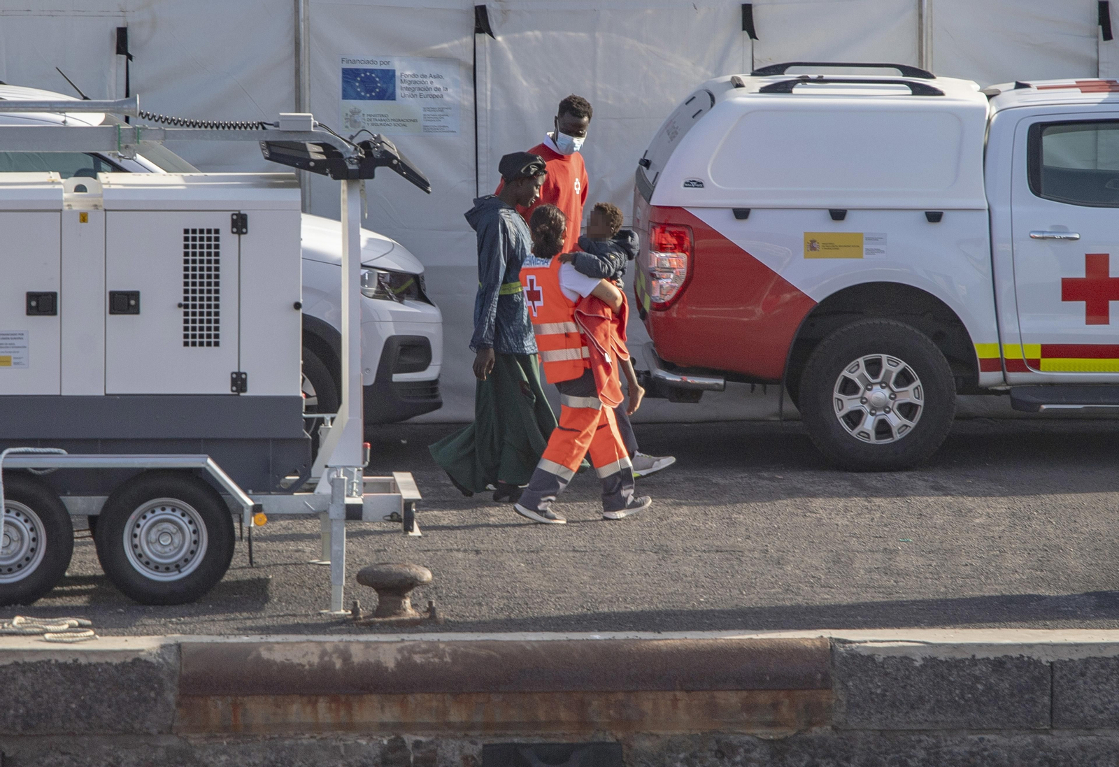 Archivo - Agentes de los Servicios de Emergencias atienden a una mujer y un menor a su llegada al Puerto de La Restinga